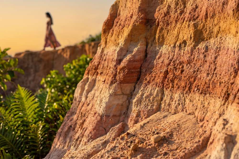 Detalhe das camadas e tons avermelhados das falésias monumentais da Praia de Taípe, em Trancoso, Bahia