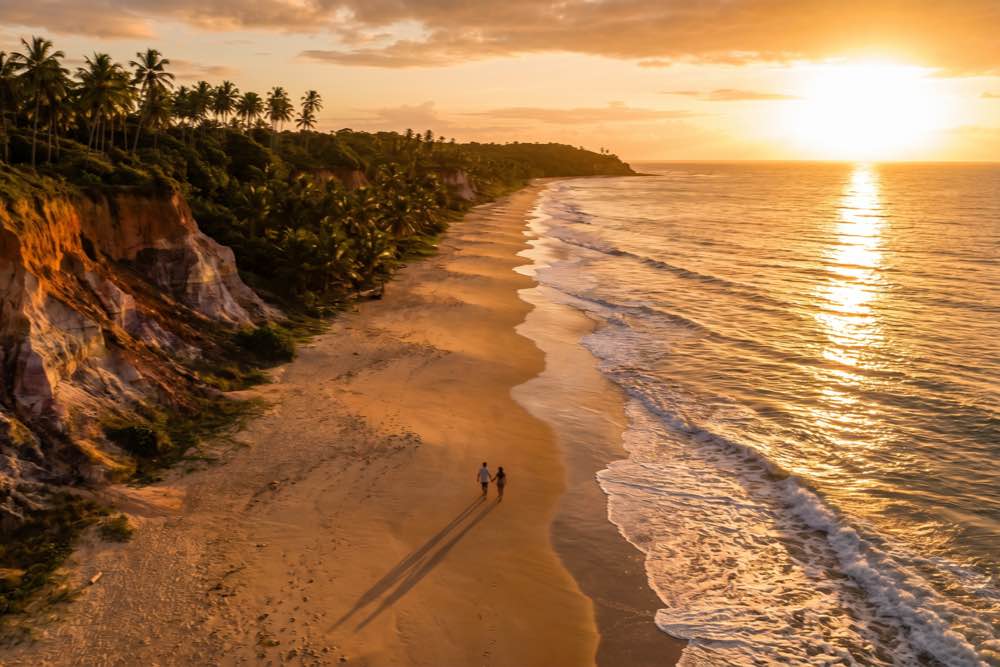 Vista aérea da praia extensa e batida pela maré no eixo Trancoso-Arraial d'Ajuda, Porto Seguro, Bahia