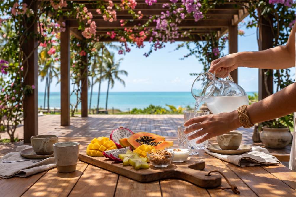 Café da manhã tropical com frutas frescas servido à beira-mar, no litoral de Trancoso, próximo à Praia de Taípe, Bahia