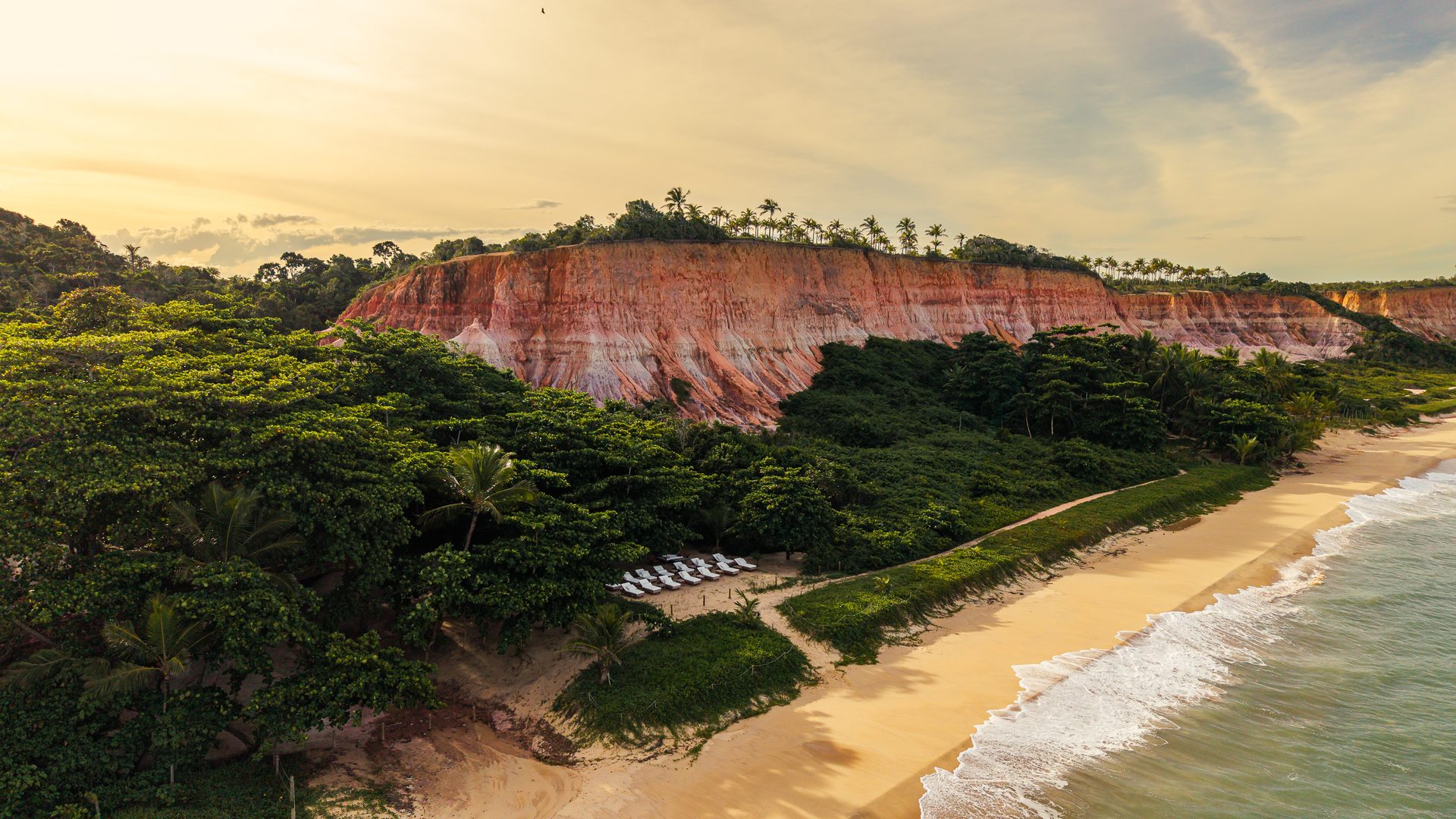 Falésias avermelhadas e mata sobre a praia em Trancoso, Taípe