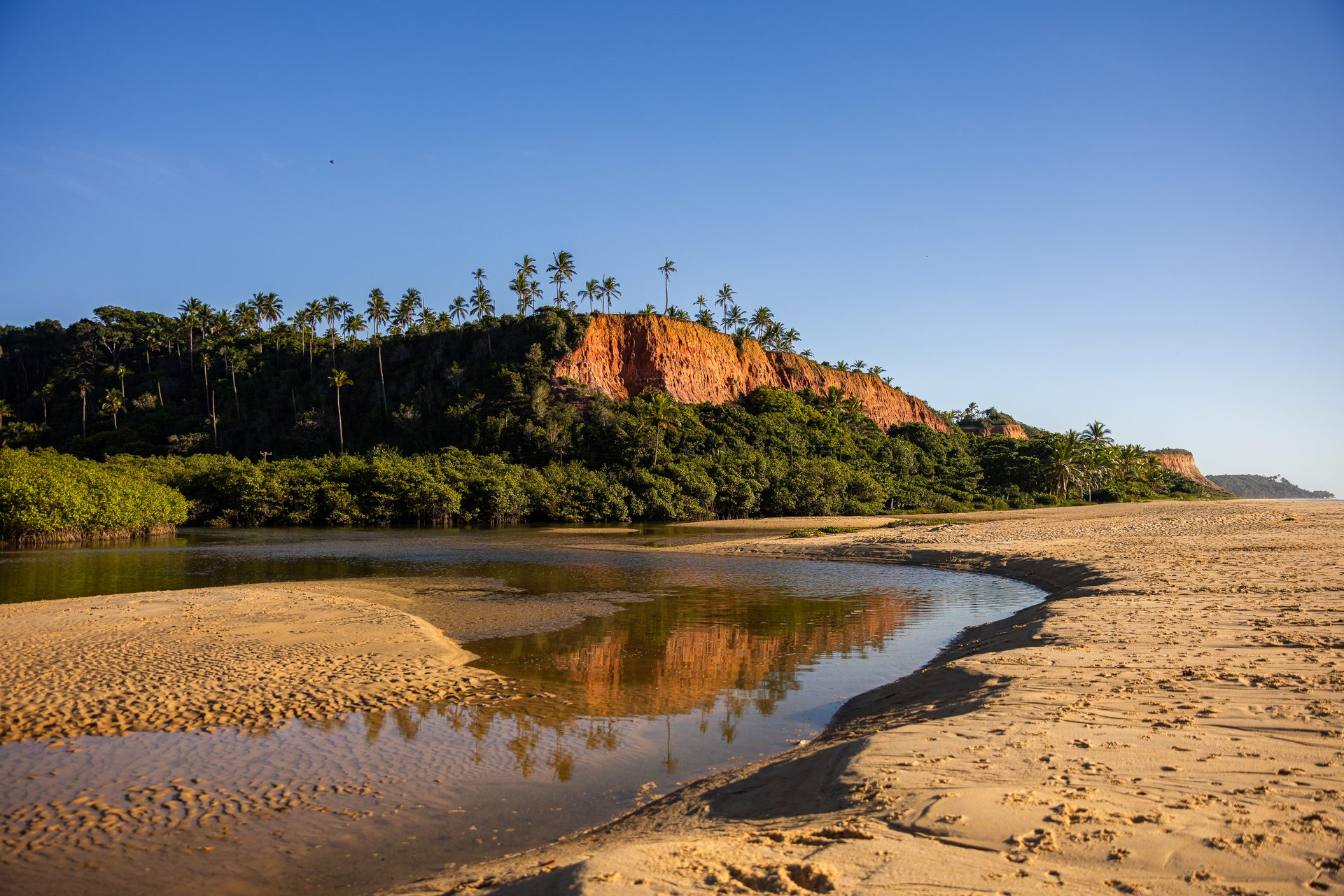 Falésia refletida na maré em Trancoso, Taípe