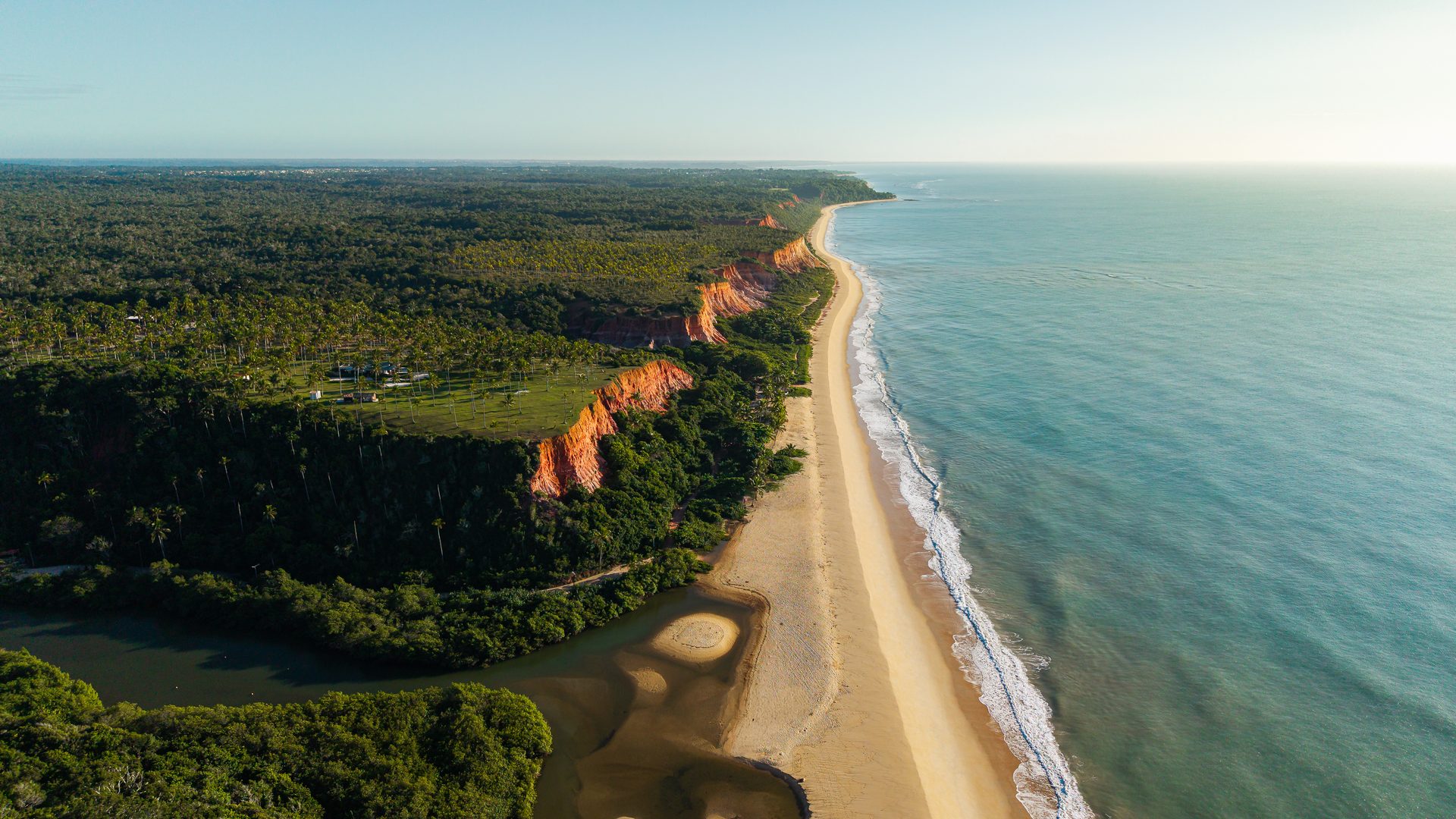 Falésia coberta de Mata Atlântica sobre a praia extensa da Praia de Taípe, Trancoso, Bahia