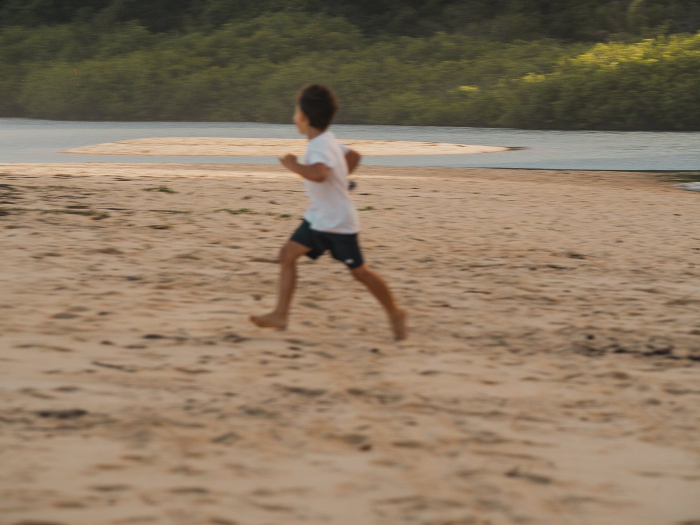 Criança correndo na praia ao entardecer, Trancoso, Bahia · imagem meramente ilustrativa