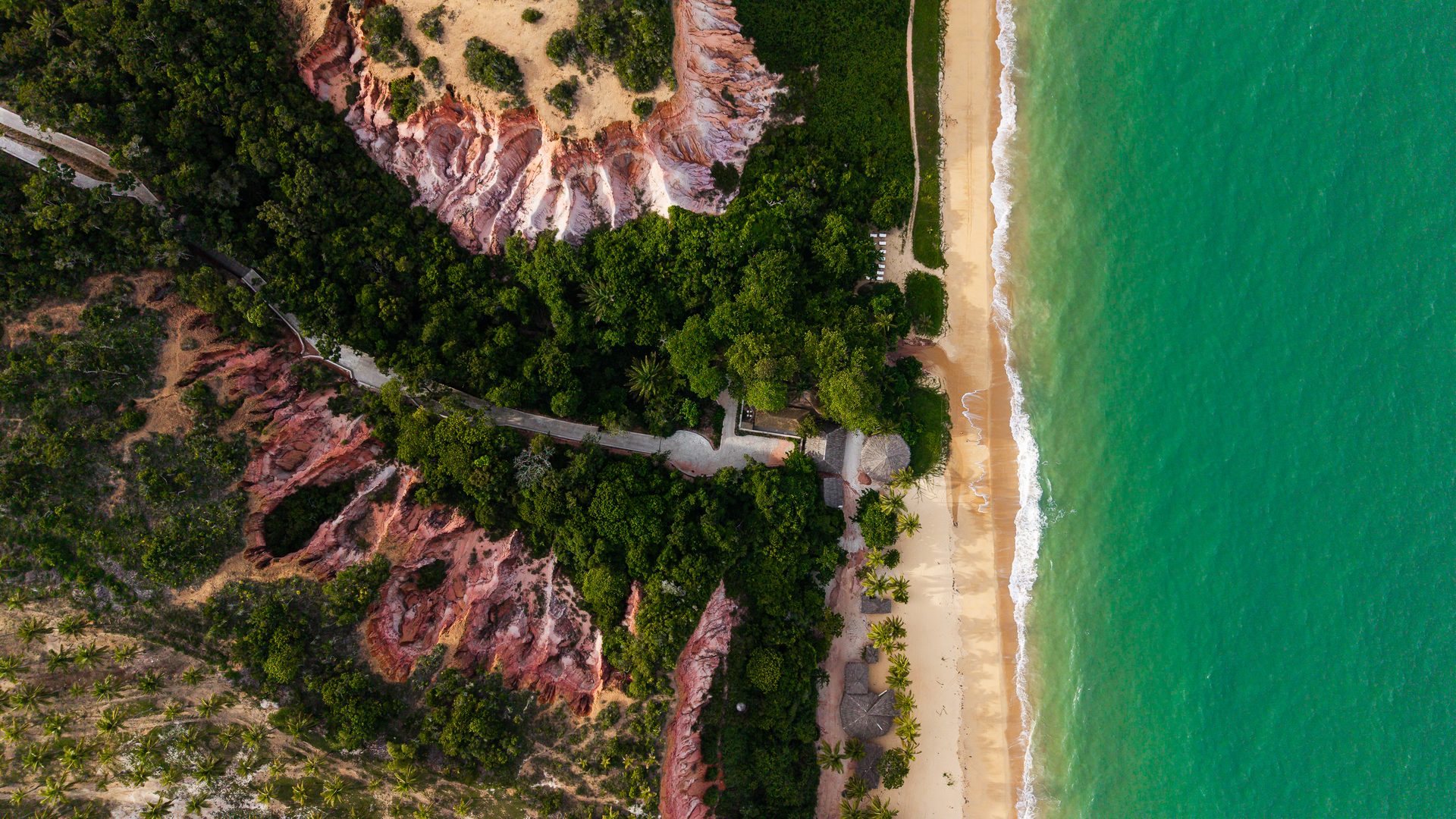 Falésia rosada, praia e mar turquesa em Taípe, Trancoso