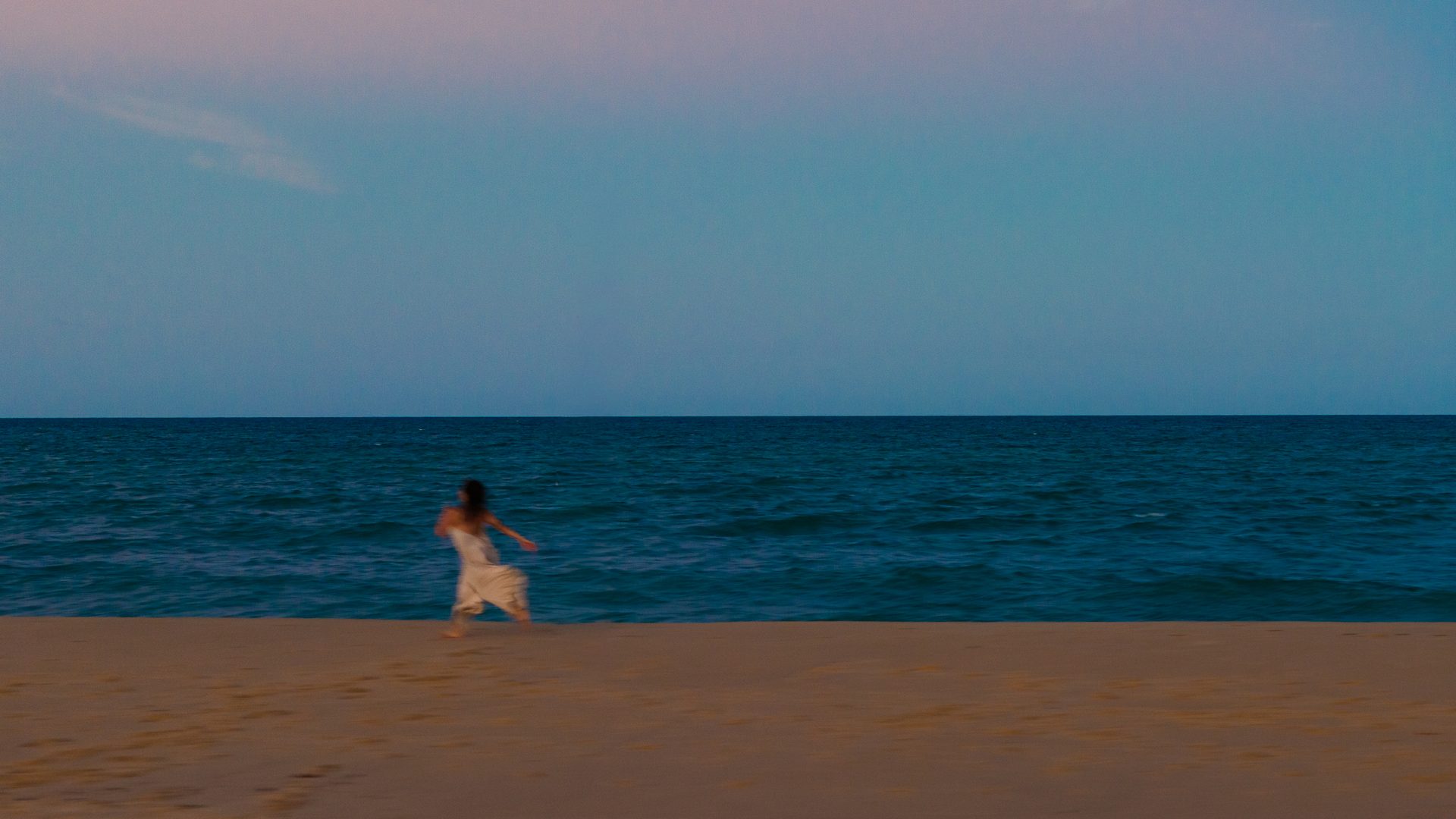 Figura de branco à beira-mar na praia de Taípe, Trancoso