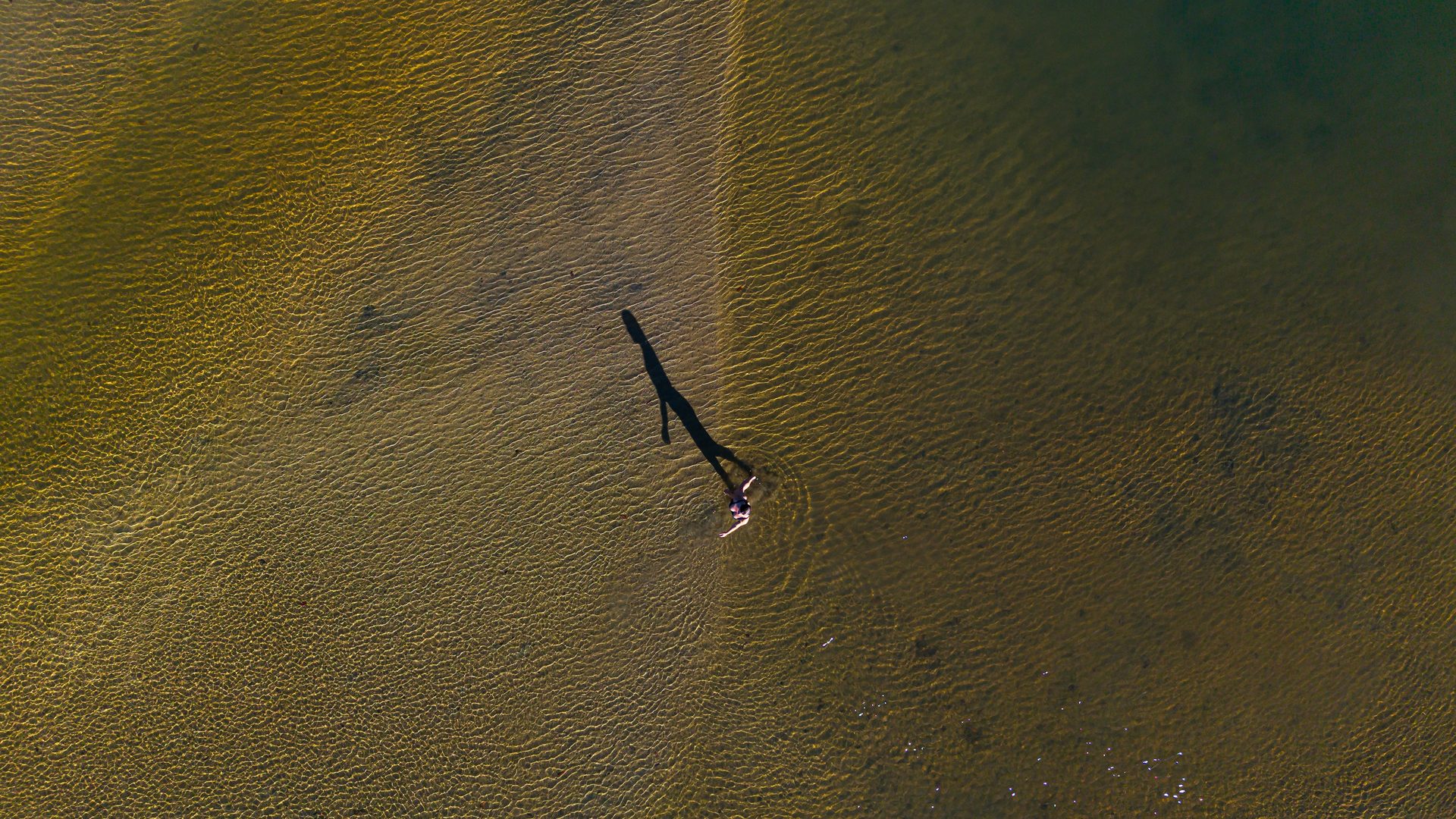 Pessoa em pé nas águas rasas ao entardecer, vista aérea, Taípe, Trancoso