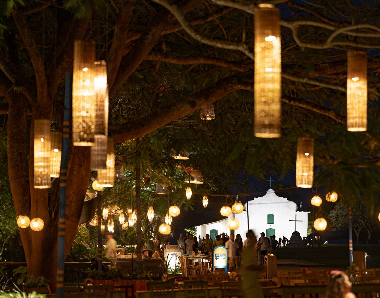 O Quadrado de Trancoso sob as luminárias de fibra ao anoitecer, Bahia