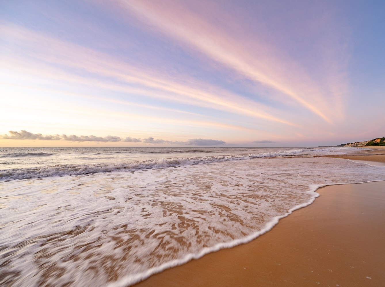 Ondas quebrando na areia ao pôr do sol, Trancoso, Bahia, imagem meramente ilustrativa